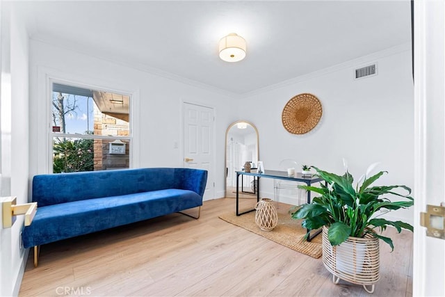 sitting room featuring ornamental molding and light wood-type flooring