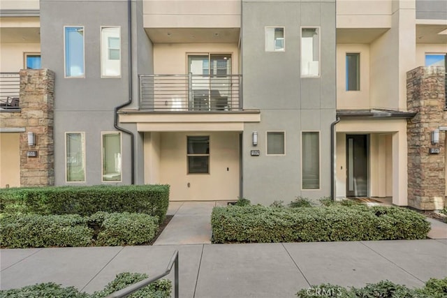 view of front of house featuring stone siding and stucco siding