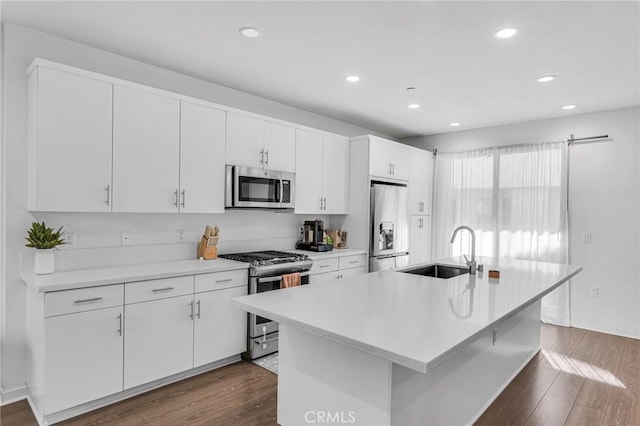 kitchen featuring an island with sink, appliances with stainless steel finishes, sink, and white cabinets