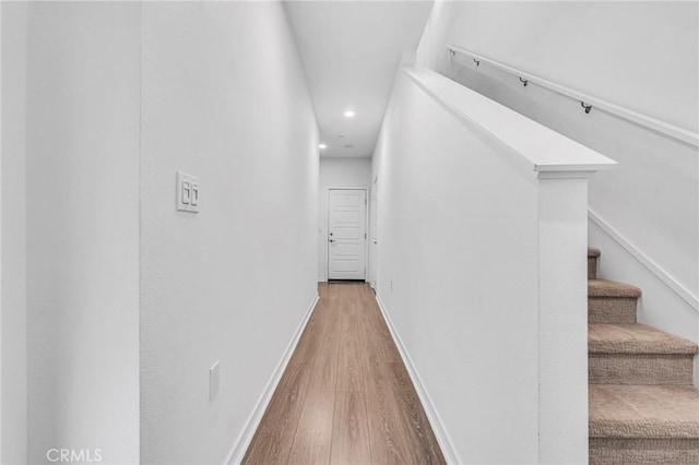 hall featuring stairway, recessed lighting, wood finished floors, and baseboards