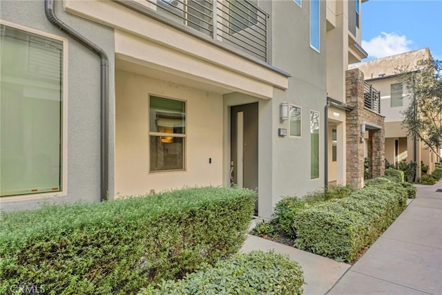 entrance to property with stone siding and stucco siding