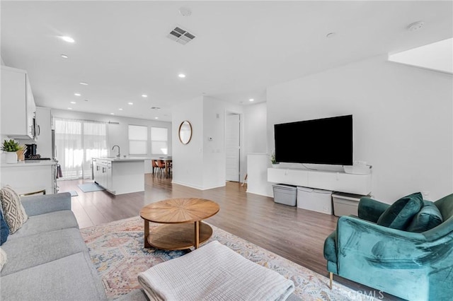 living area featuring visible vents, wood finished floors, and recessed lighting