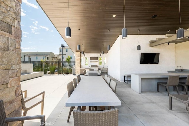 view of patio featuring exterior bar and fence