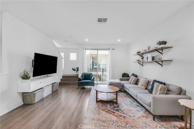 living room featuring light wood finished floors, recessed lighting, visible vents, stairway, and baseboards