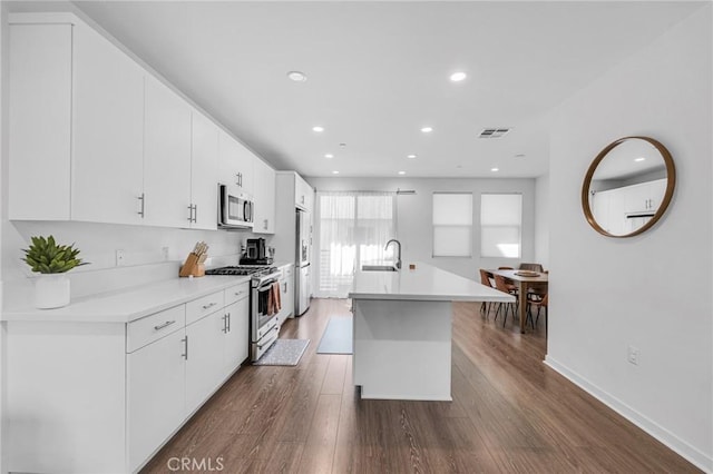 kitchen featuring light countertops, visible vents, appliances with stainless steel finishes, white cabinetry, and a sink