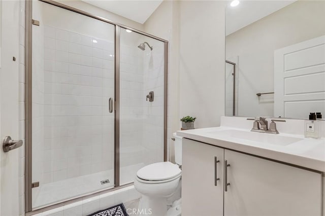 bathroom with toilet, a stall shower, and vanity