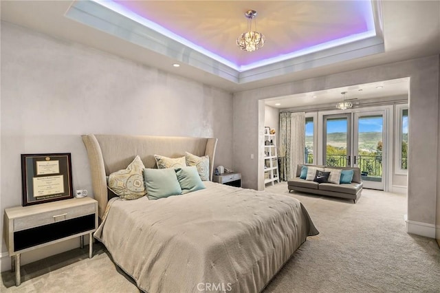 bedroom with an inviting chandelier, access to exterior, french doors, light carpet, and a raised ceiling