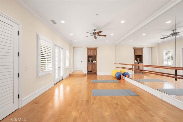 workout area with crown molding, a wealth of natural light, ceiling fan, and light wood-type flooring