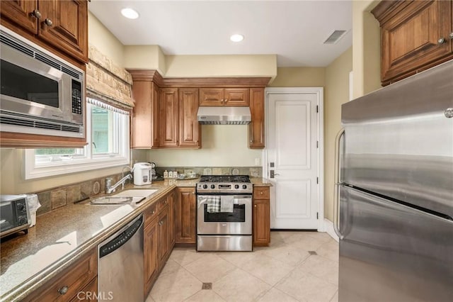 kitchen with light tile patterned flooring, appliances with stainless steel finishes, and sink