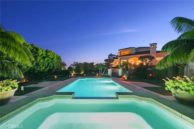 view of pool at dusk