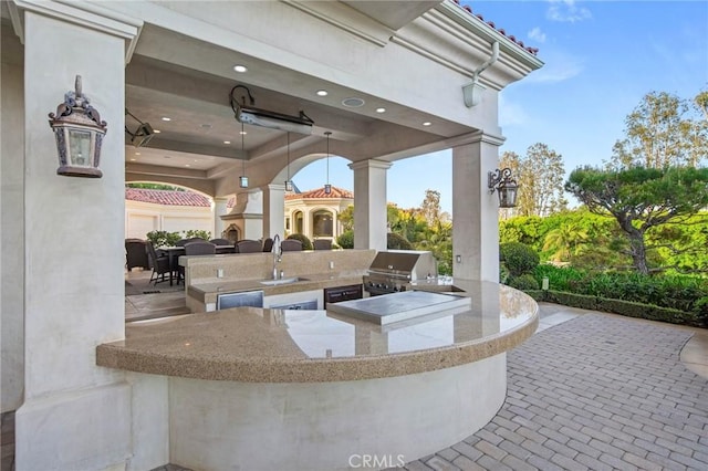 view of patio featuring a grill, an outdoor wet bar, and an outdoor kitchen