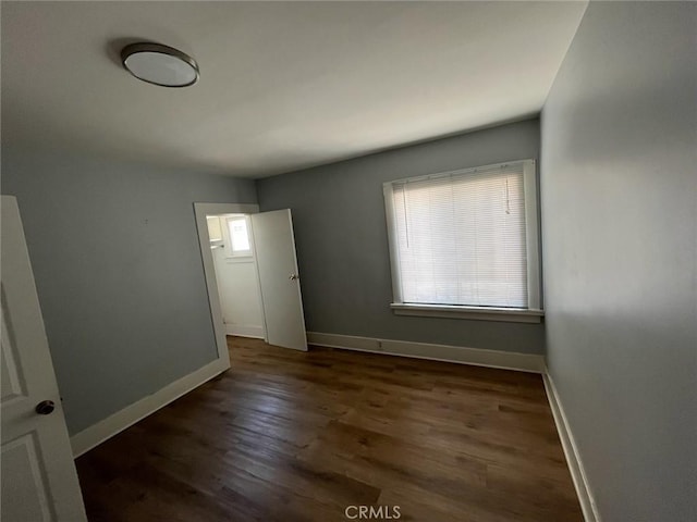 unfurnished bedroom with dark wood-type flooring