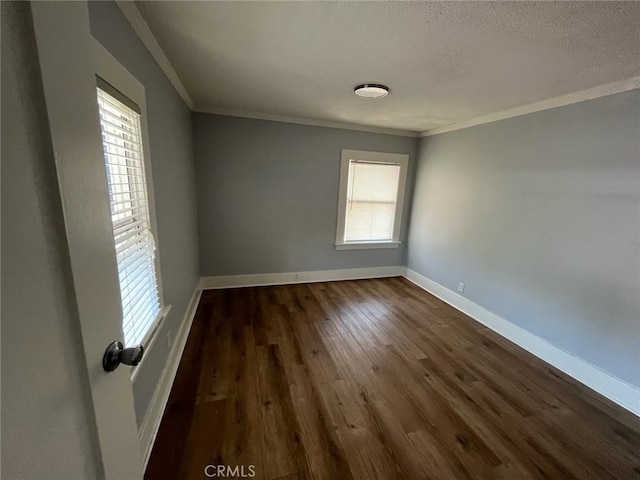 spare room featuring ornamental molding and dark wood-type flooring