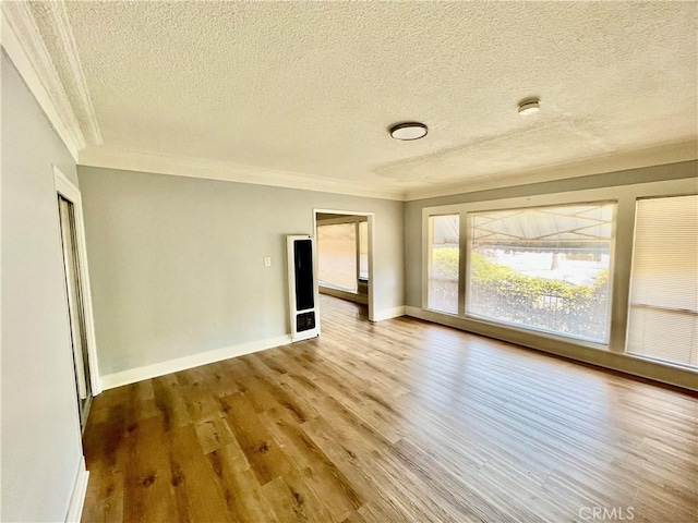 1143 S Manhattan Pl, Los Angeles, CA 90019 - empty room with a textured ceiling, wood finished floors, crown molding, baseboards, and a smoke detector