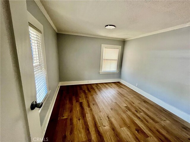1143 S Manhattan Pl, Los Angeles, CA 90019 - spare room featuring plenty of natural light, ornamental molding, wood finished floors, baseboards, and a textured ceiling