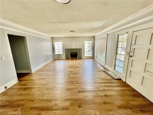 1143 S Manhattan Pl, Los Angeles, CA 90019 - unfurnished living room featuring crown molding, a textured ceiling, light wood-style flooring, a fireplace, and baseboards