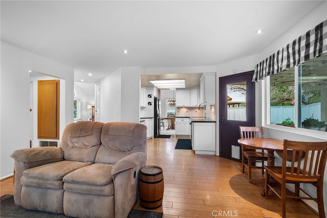 living room with sink and light hardwood / wood-style flooring