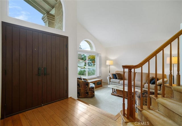 foyer entrance featuring hardwood / wood-style flooring and high vaulted ceiling