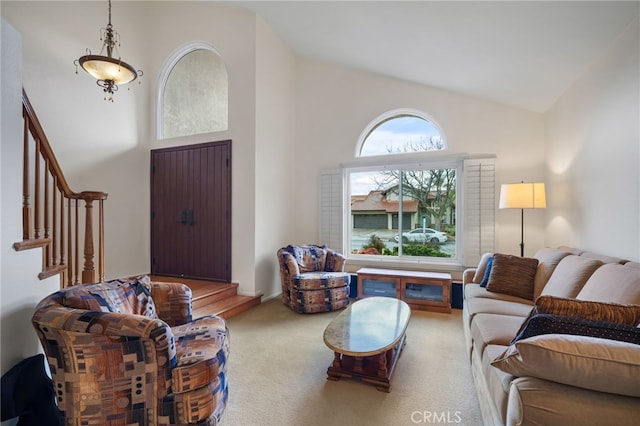 carpeted living room featuring plenty of natural light and high vaulted ceiling