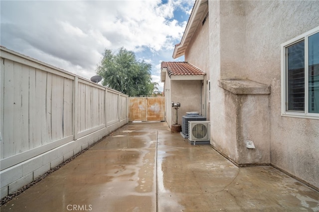 view of side of property with a patio and ac unit