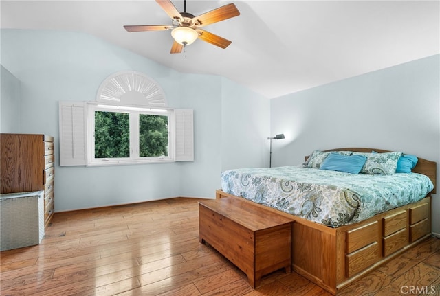 bedroom with ceiling fan, vaulted ceiling, and light hardwood / wood-style flooring