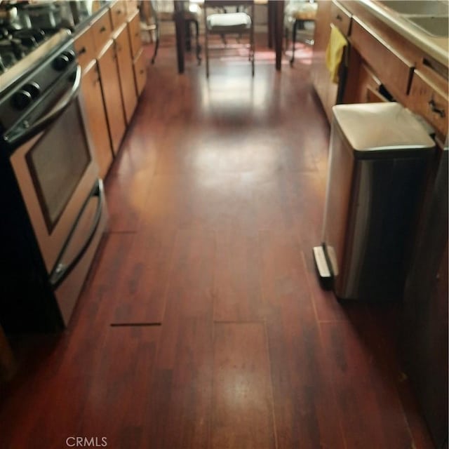 kitchen featuring stainless steel range and dark hardwood / wood-style floors