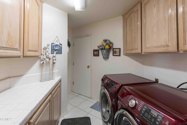 laundry area featuring independent washer and dryer, cabinets, and light tile patterned floors