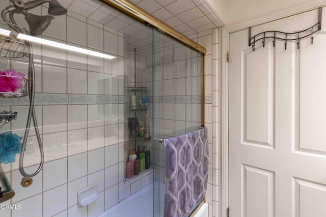 bathroom with bath / shower combo with glass door