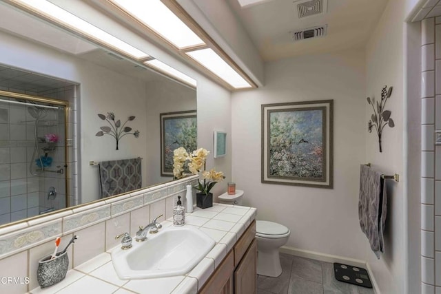 bathroom with a shower with shower door, backsplash, tile patterned flooring, vanity, and toilet