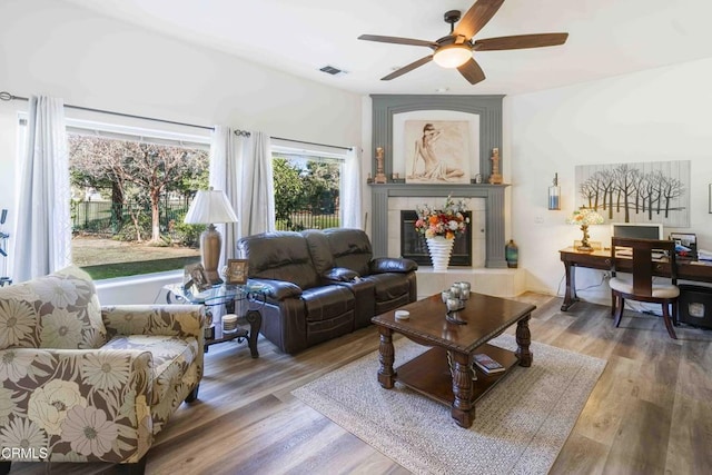 living room featuring ceiling fan, a fireplace, and hardwood / wood-style floors