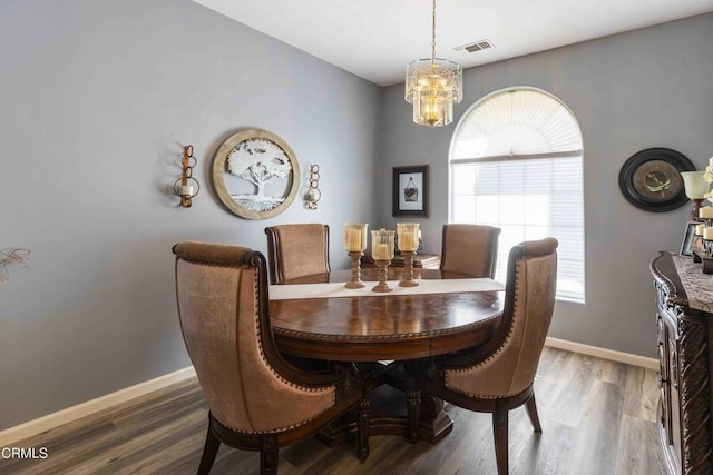 dining room featuring an inviting chandelier and dark hardwood / wood-style flooring