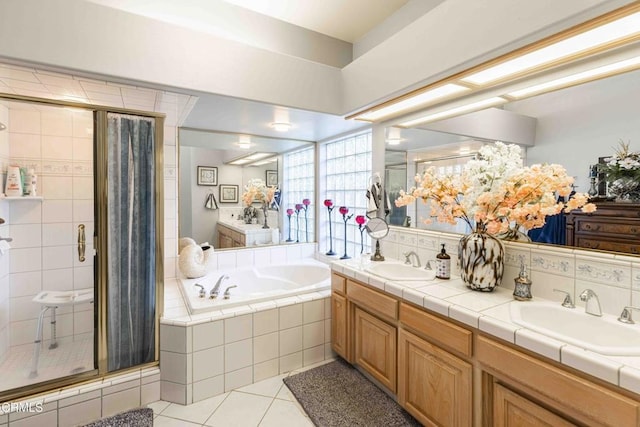 bathroom with tile patterned flooring, vanity, and separate shower and tub