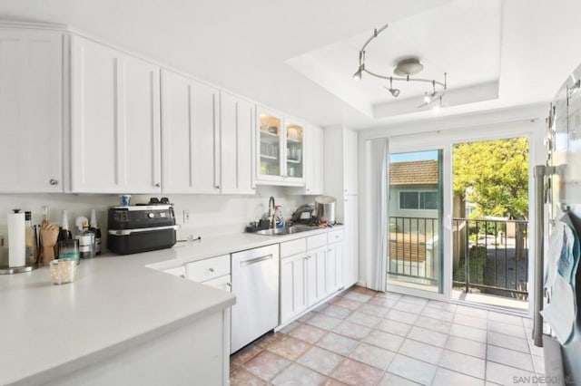 kitchen with a tray ceiling, dishwasher, and white cabinets