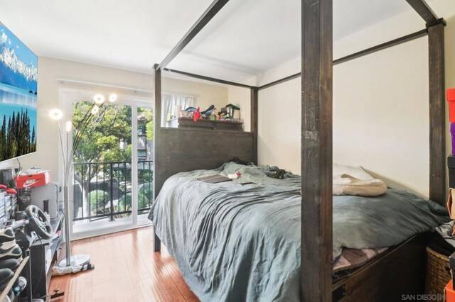 bedroom with access to exterior and hardwood / wood-style flooring