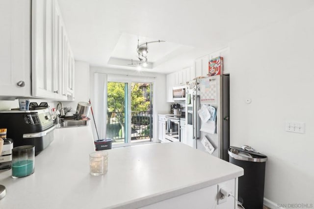 kitchen with white cabinetry, sink, a raised ceiling, and fridge with ice dispenser