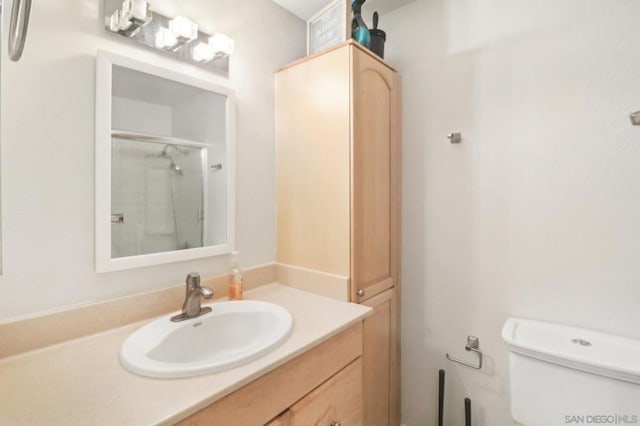 bathroom with vanity, toilet, and a shower with shower door