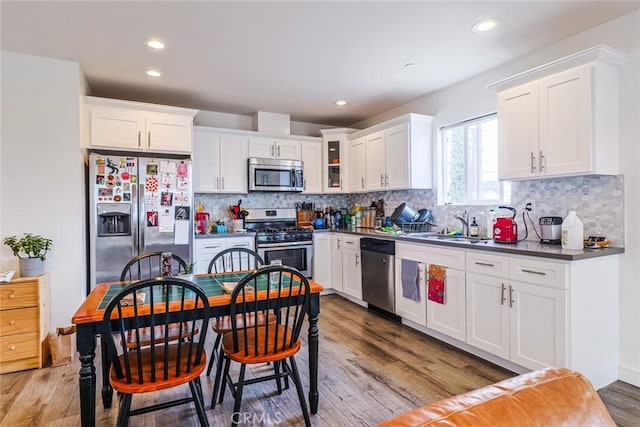 kitchen featuring light wood-type flooring, stainless steel appliances, sink, and white cabinets