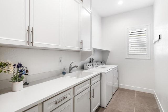 laundry room featuring cabinets, sink, washing machine and dryer, and light tile patterned floors