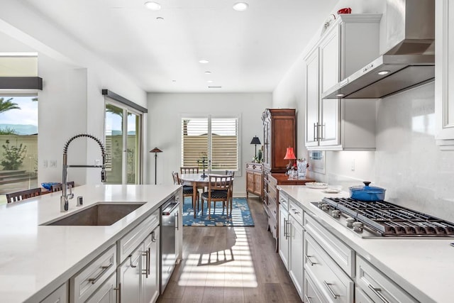 kitchen with sink, stainless steel appliances, white cabinets, dark hardwood / wood-style flooring, and wall chimney exhaust hood