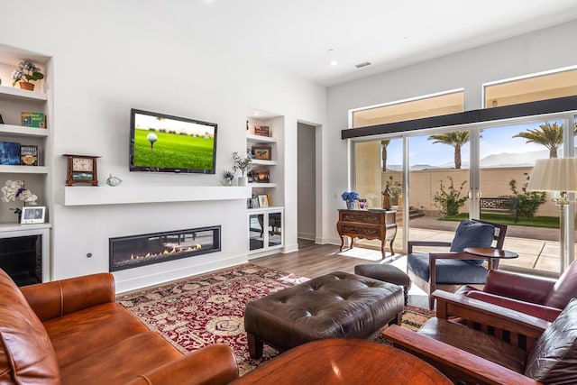 living room featuring hardwood / wood-style floors and built in features