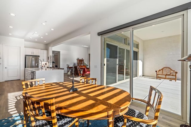 dining area with sink and light wood-type flooring