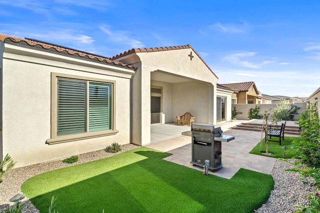 rear view of property featuring a yard and a patio area