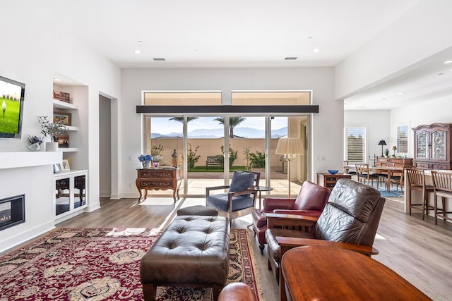 living room with hardwood / wood-style flooring, a healthy amount of sunlight, and built in features