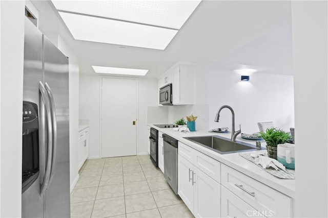 kitchen featuring white cabinetry, appliances with stainless steel finishes, light tile patterned flooring, and sink