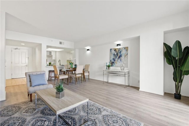 living room with sink and light wood-type flooring