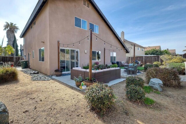 back of property featuring an outdoor living space and a patio