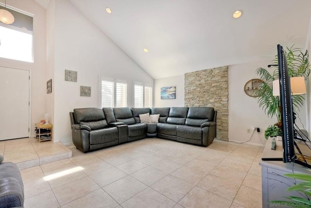 living room with light tile patterned floors and high vaulted ceiling