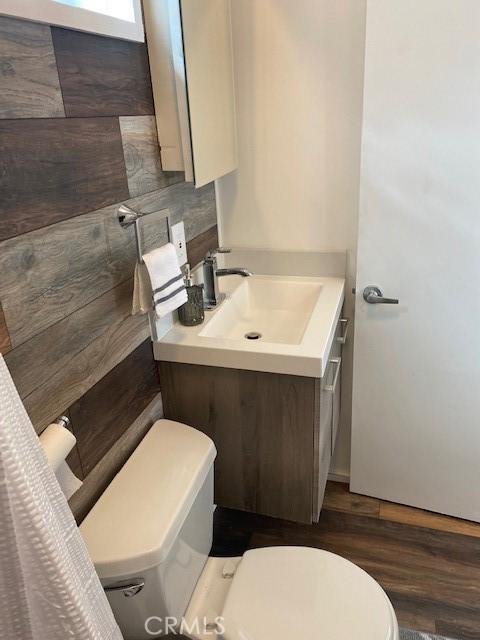 bathroom with vanity, toilet, and hardwood / wood-style floors