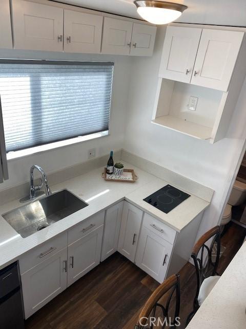 kitchen featuring dark wood-type flooring, plenty of natural light, sink, and white cabinets