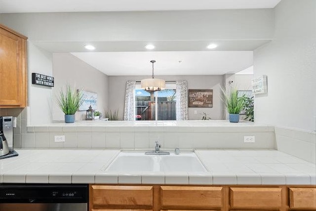 kitchen with tile counters, black dishwasher, and sink